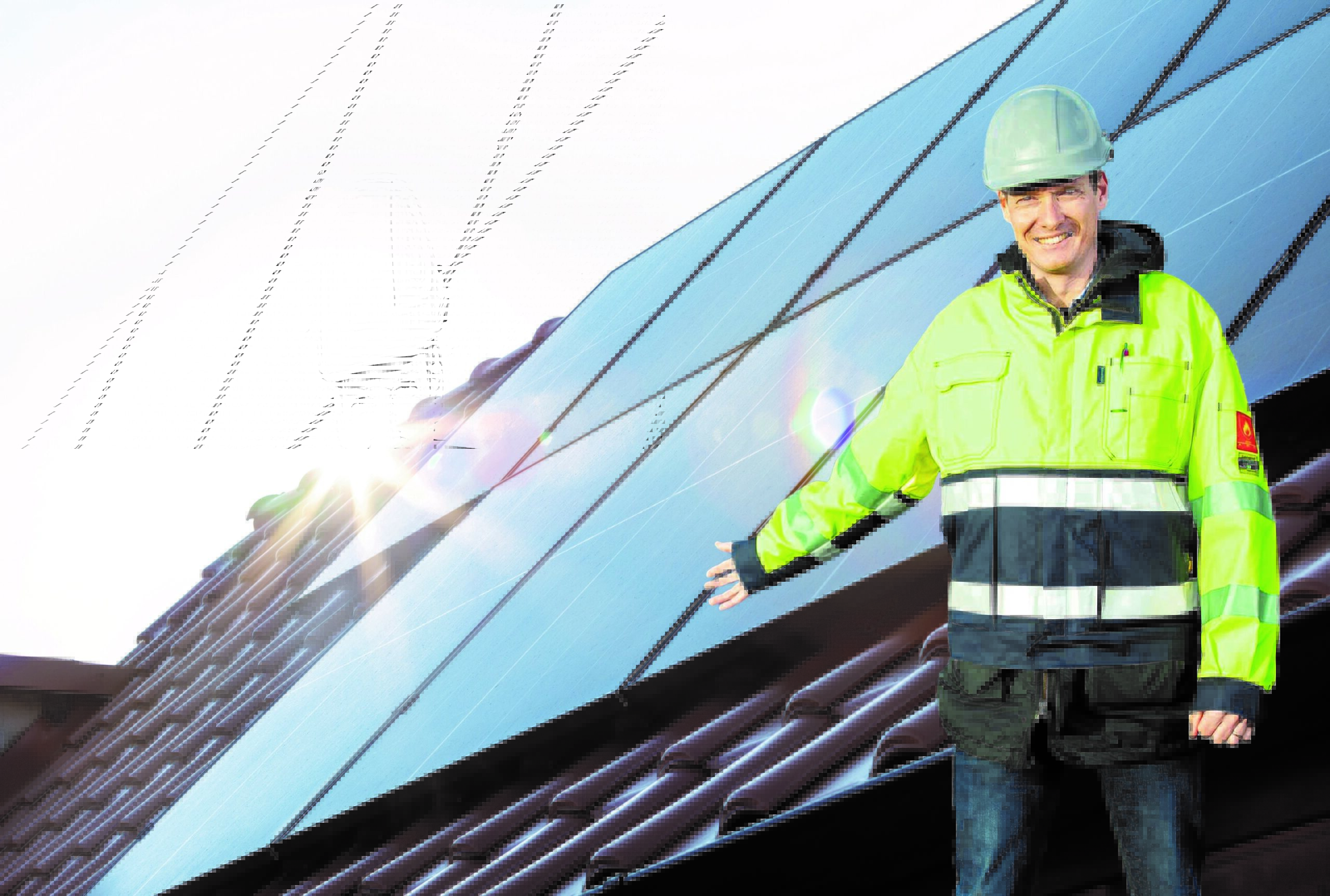 En man i varseljacka står framför ett tak med solceller.
